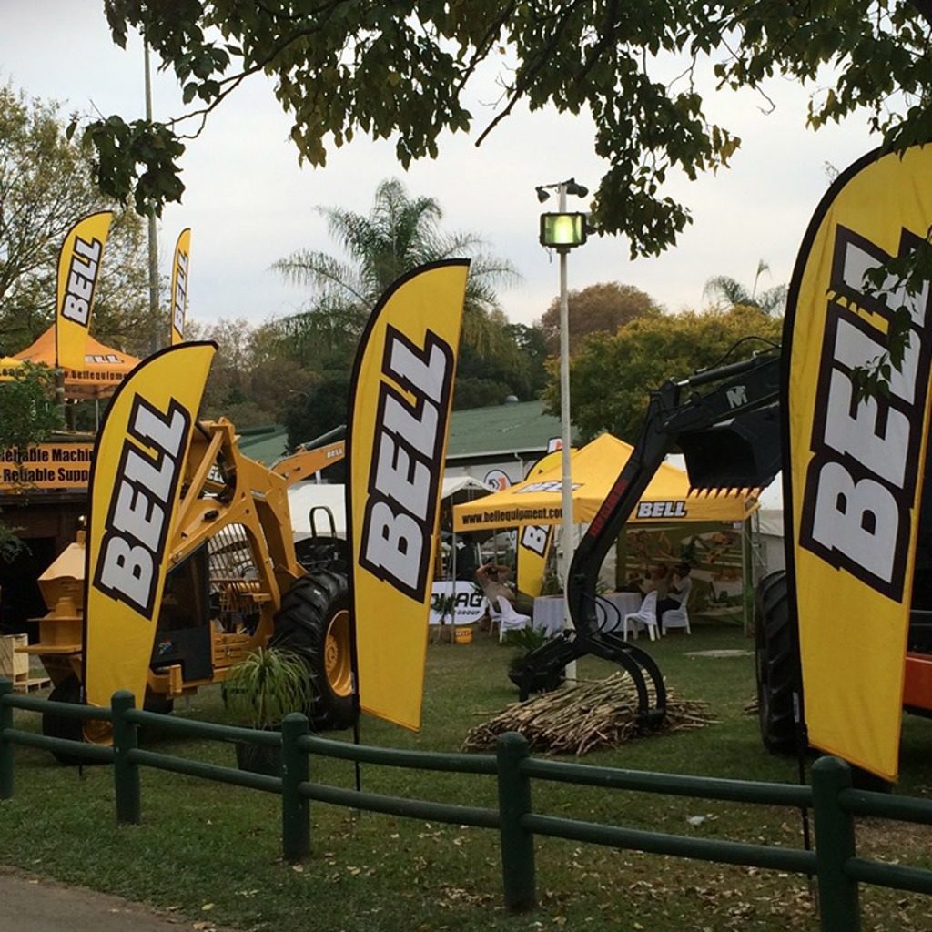 A row of branded feather flags at a sports ground