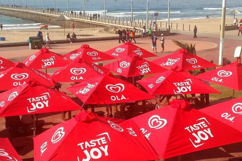 Rows of branded umbrellas along an outdoor market promenade