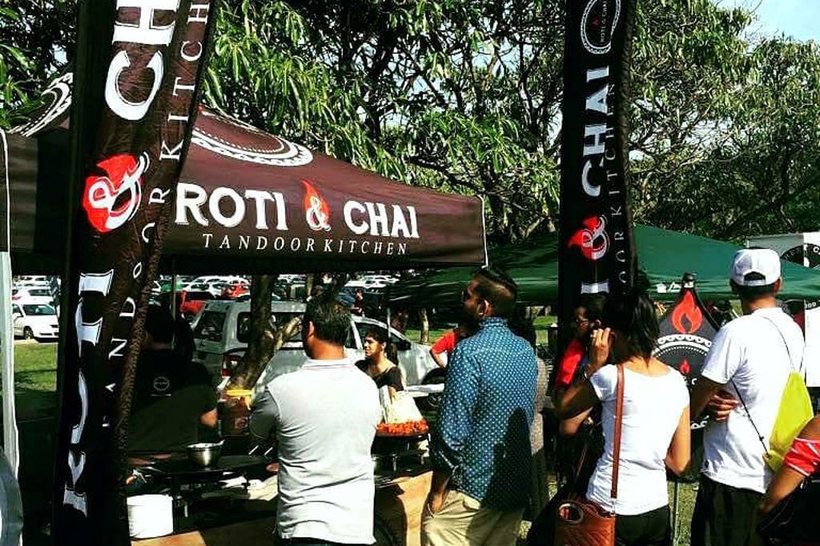 Branded street food stall with feather flags and a queue of customers