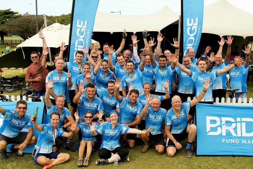 Club team photographed in front of a printed backdrop on a pitch